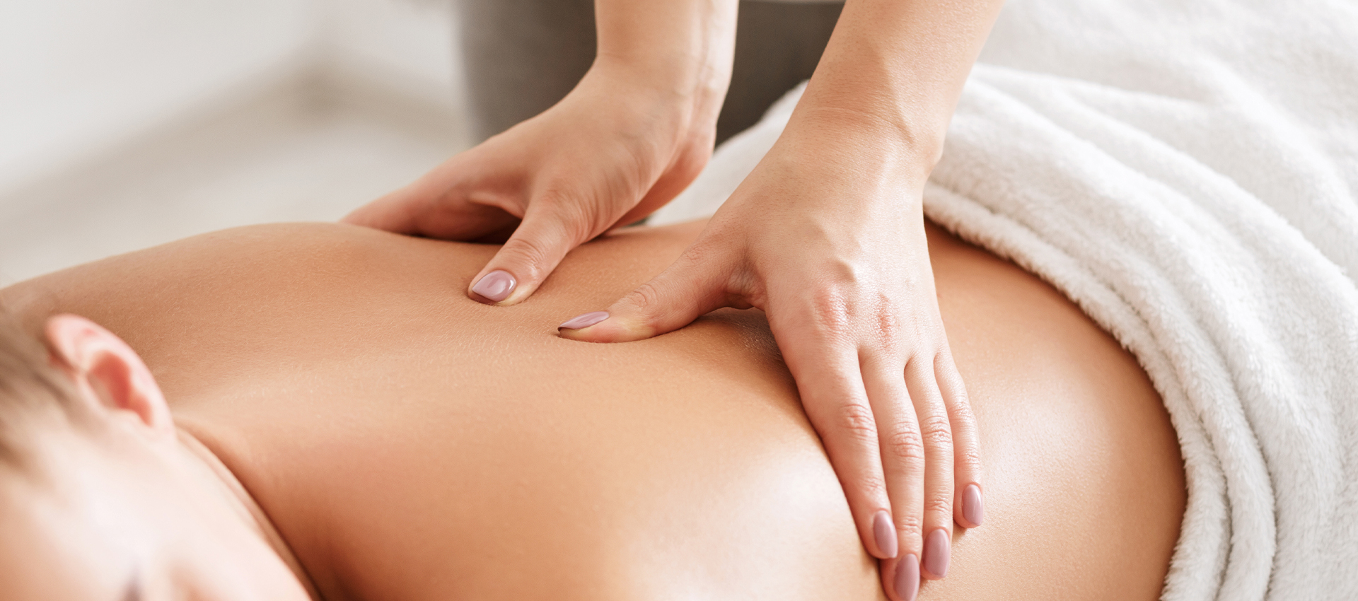 Body care. Young girl having massage, relaxing in spa salon, closeup